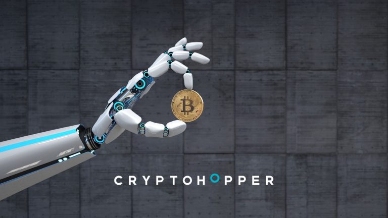 A robotic hand holds a Bitcoin coin in front of a concrete wall. Below the hand, the word "CRYPTOHOPPER" is written in bold white letters with a blue letter 'O'.